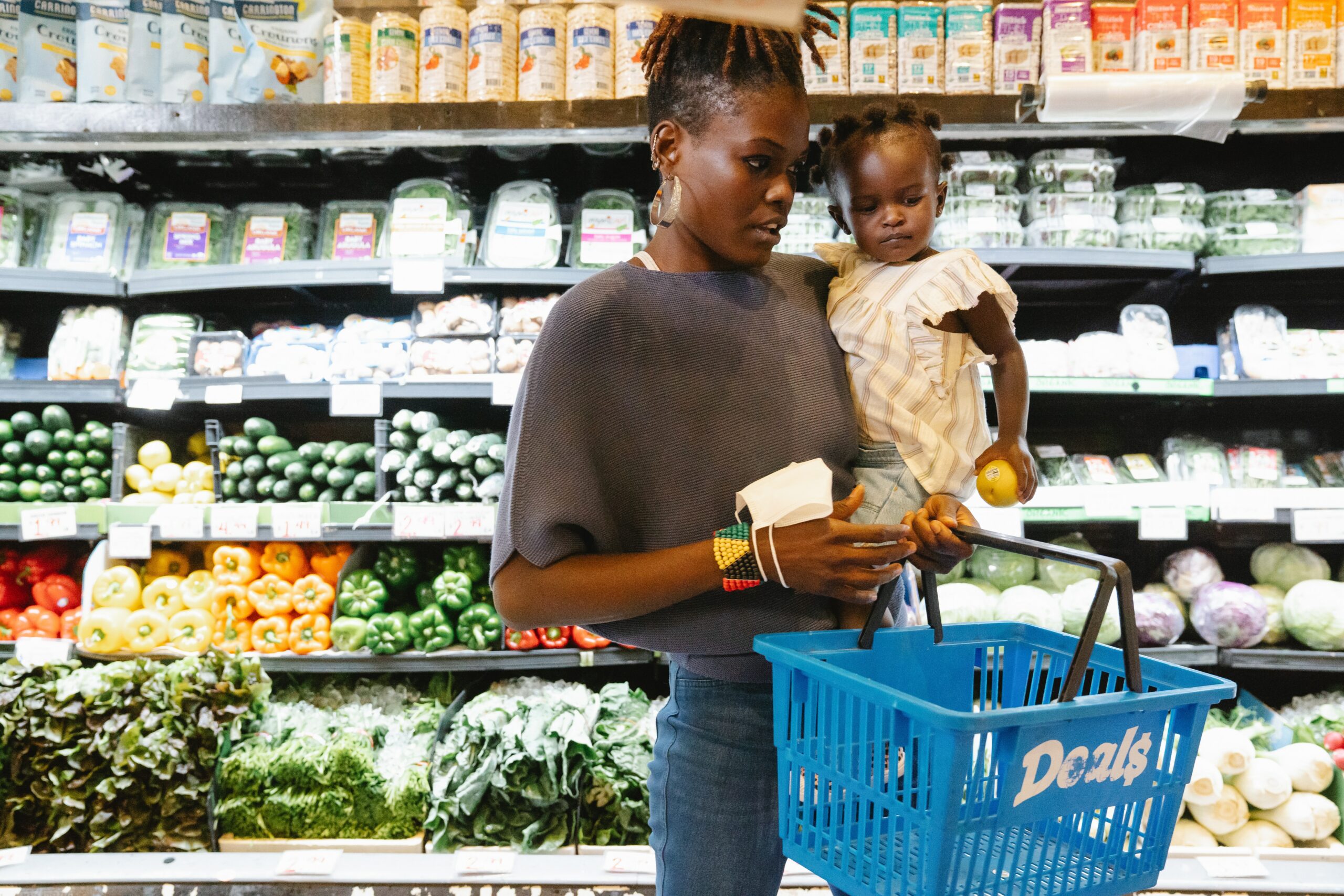 women grocery shopping with baby